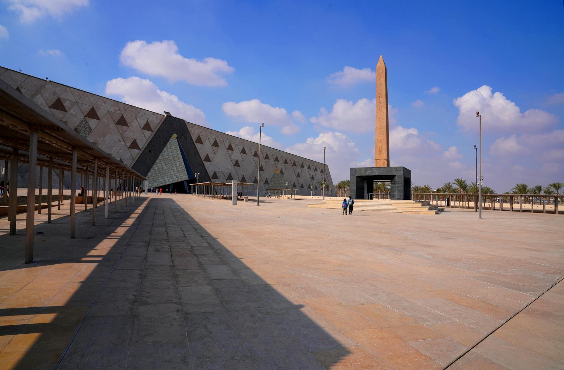 The forecourt and obelisk of the Grand Egyptian Museum in Giza under a blue sky