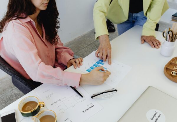 financial inclusion solutions Two colleagues work together on financial graphs, promoting teamwork in a modern office setting.