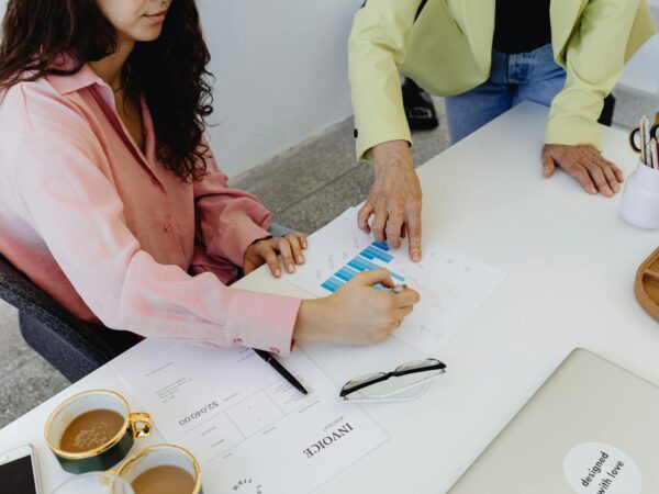 financial inclusion solutions Two colleagues work together on financial graphs, promoting teamwork in a modern office setting.