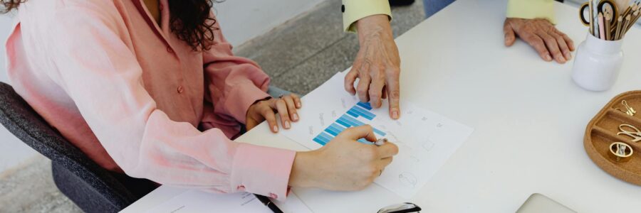 financial inclusion solutions Two colleagues work together on financial graphs, promoting teamwork in a modern office setting.
